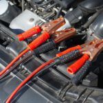 Pinzas de arranque conectadas a la batería de un coche en un taller de Guadalajara