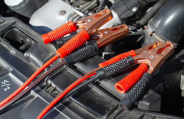 Pinzas de arranque conectadas a la batería de un coche en un taller de Guadalajara